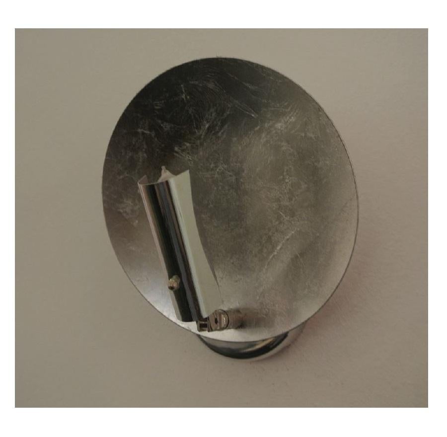 The Luna 220 wall sconce is part of the collection Luci d’Oro by Catellani & Smith. It consists of a round aluminum disc which was laminated with silver leaf. The light bulb is fixed at a flexible arm which has a visor, so the light is reflected out