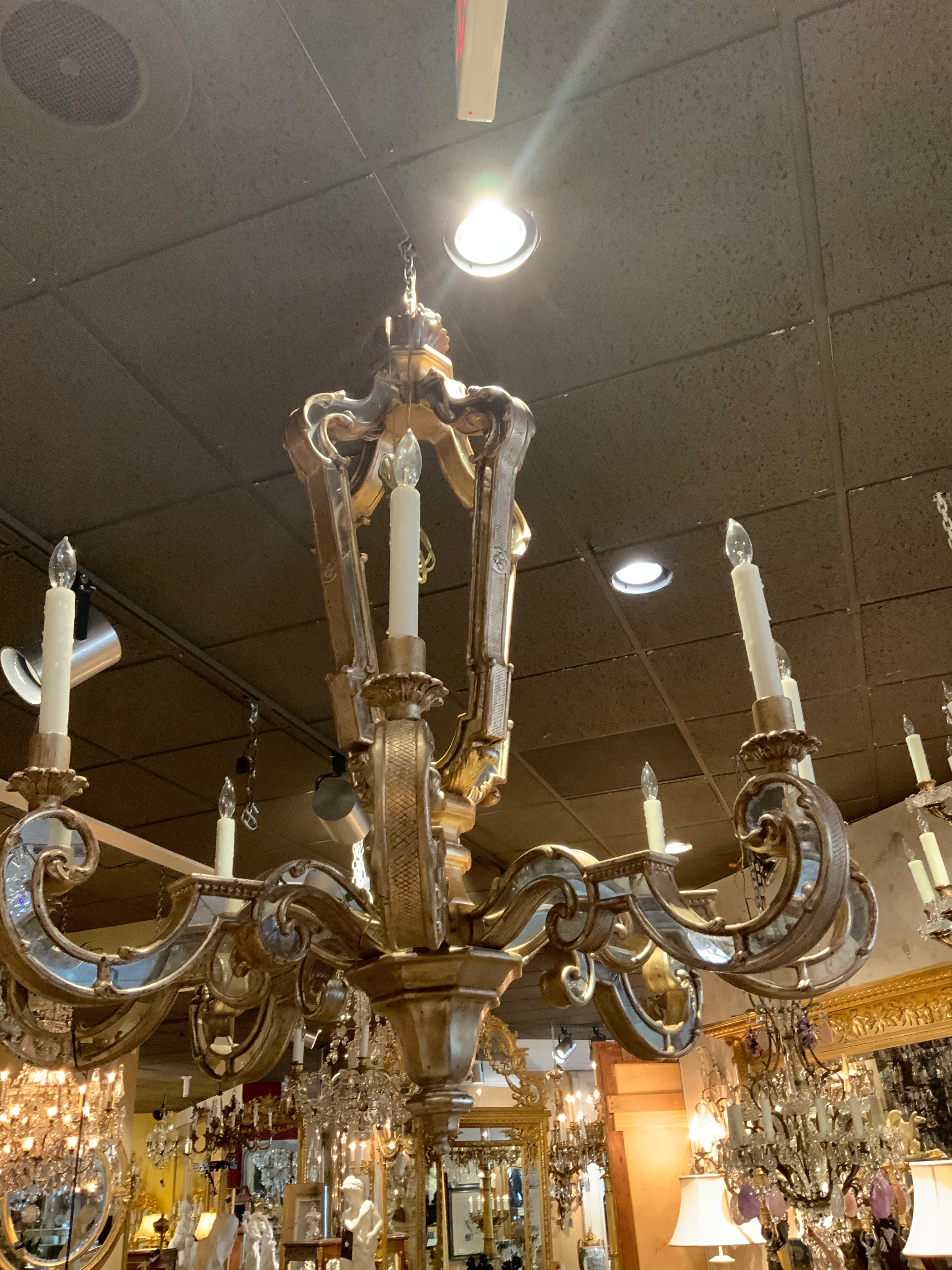 Decorative silver leaf wood carved mirror having eight scrolling arms and lights. Mirrors are
Inlaid into the body and the arms of this attractive chandelier.