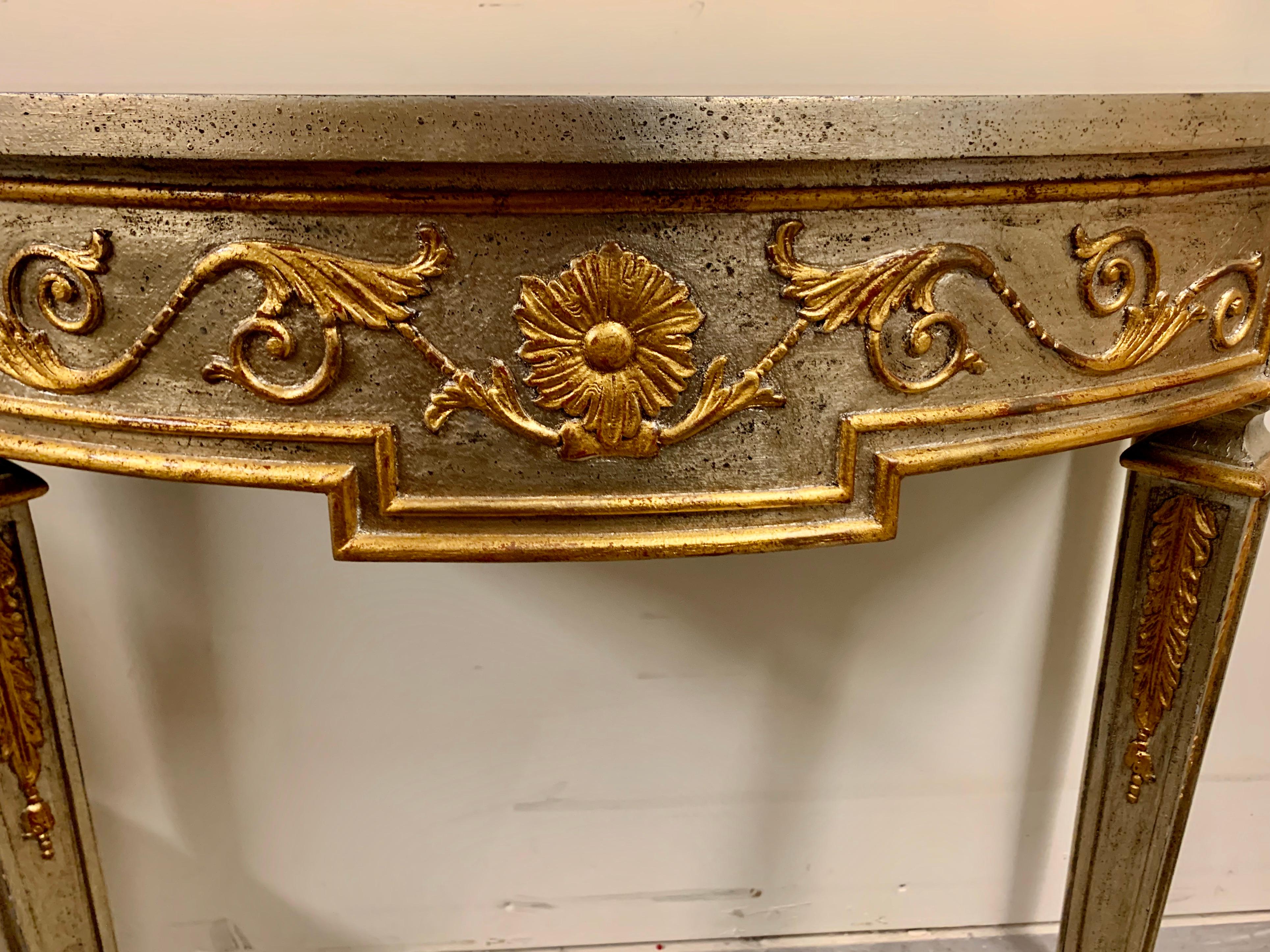 Sliver leafed demi lune table. The frieze on the apron and legs are all picked out in gold leaf.
The table was created by Stuart Swan of Wellesley, Mass.
The table remains in pristine condition.
Measures: H-33.5