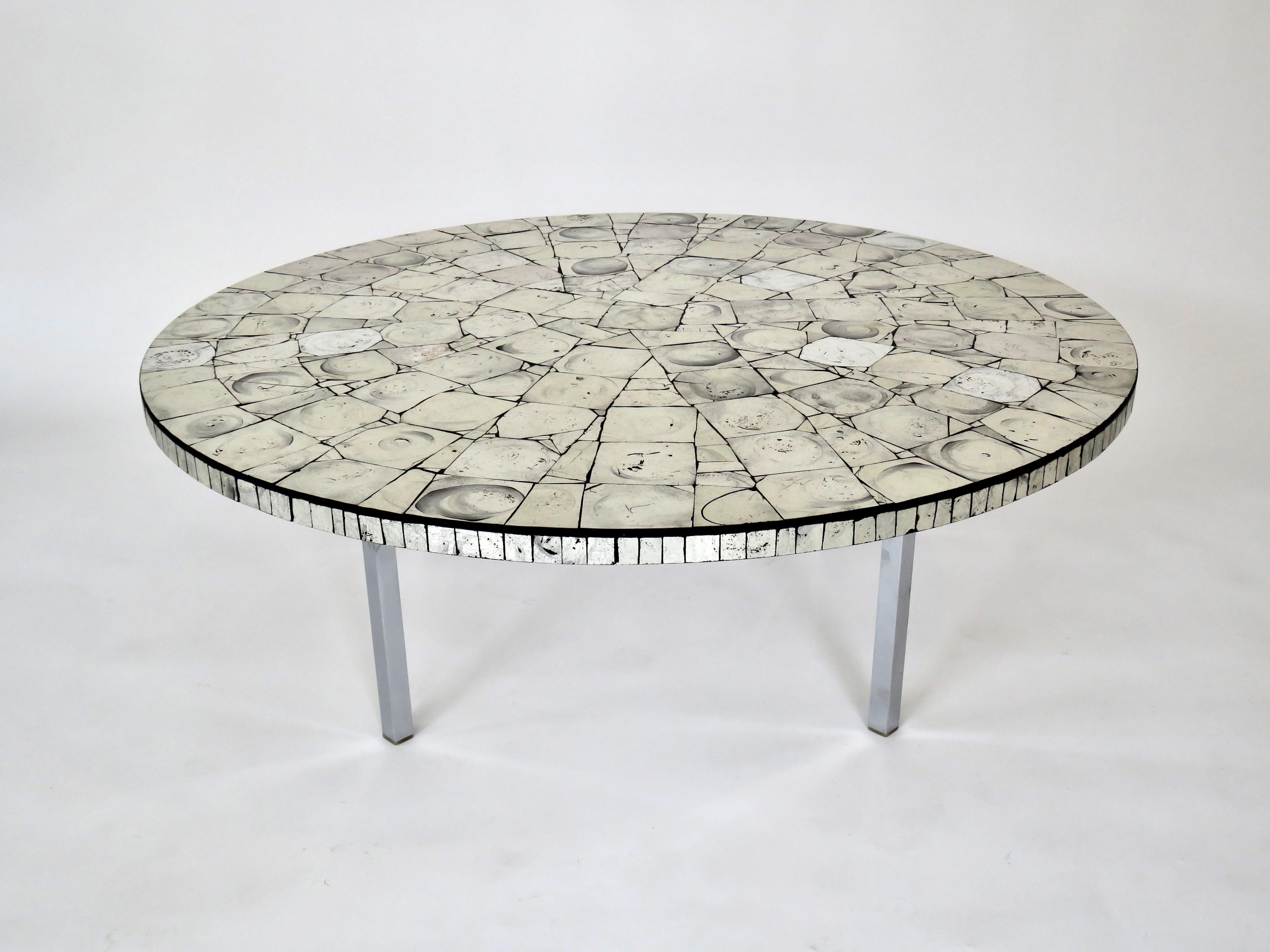 Silver Leafed Glass Mosaic French Round Coffee Table on Chrome Legs
Coffee table with a reverse real silver leaf applied to the glass on the underside round French coffee table on simple elegant chrome legs.
In between the squares of the silver leaf