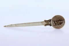 Silver letter opener with Arabic coins on top and reliefs