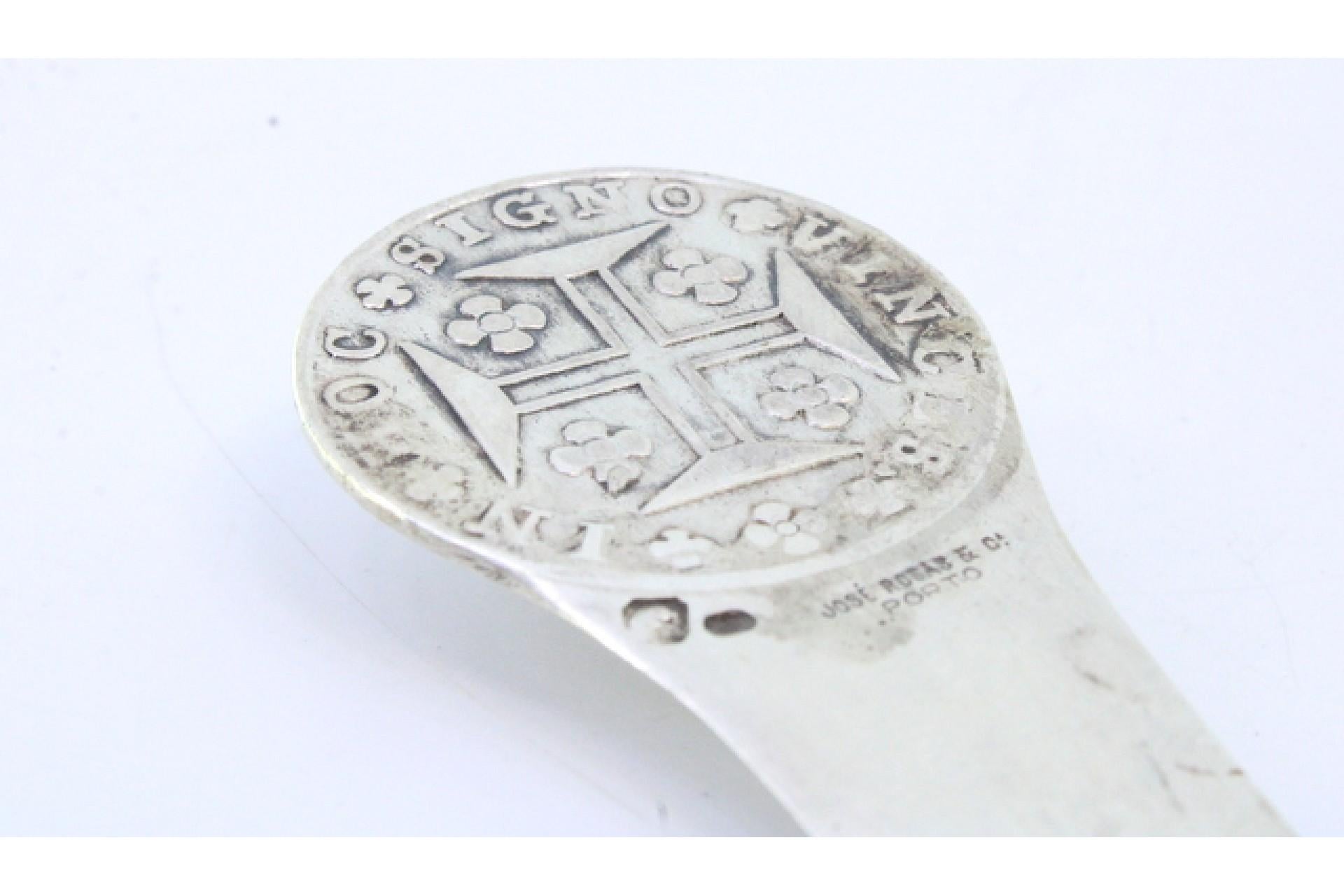 Beschreibung: Silberner Brieföffner mit Münzrelief auf der Oberseite und Kreuz auf der Klinge. 
Metall: Silber. 
Herkunft: Portugiesisch. 
Marke: boar II Titel. 
Gewicht: 62,19 Gramm. 
Abmessungen: 22cmx3,4cm. 
Inhalt: 833/1000. 
Prüfzeichen: Ja,