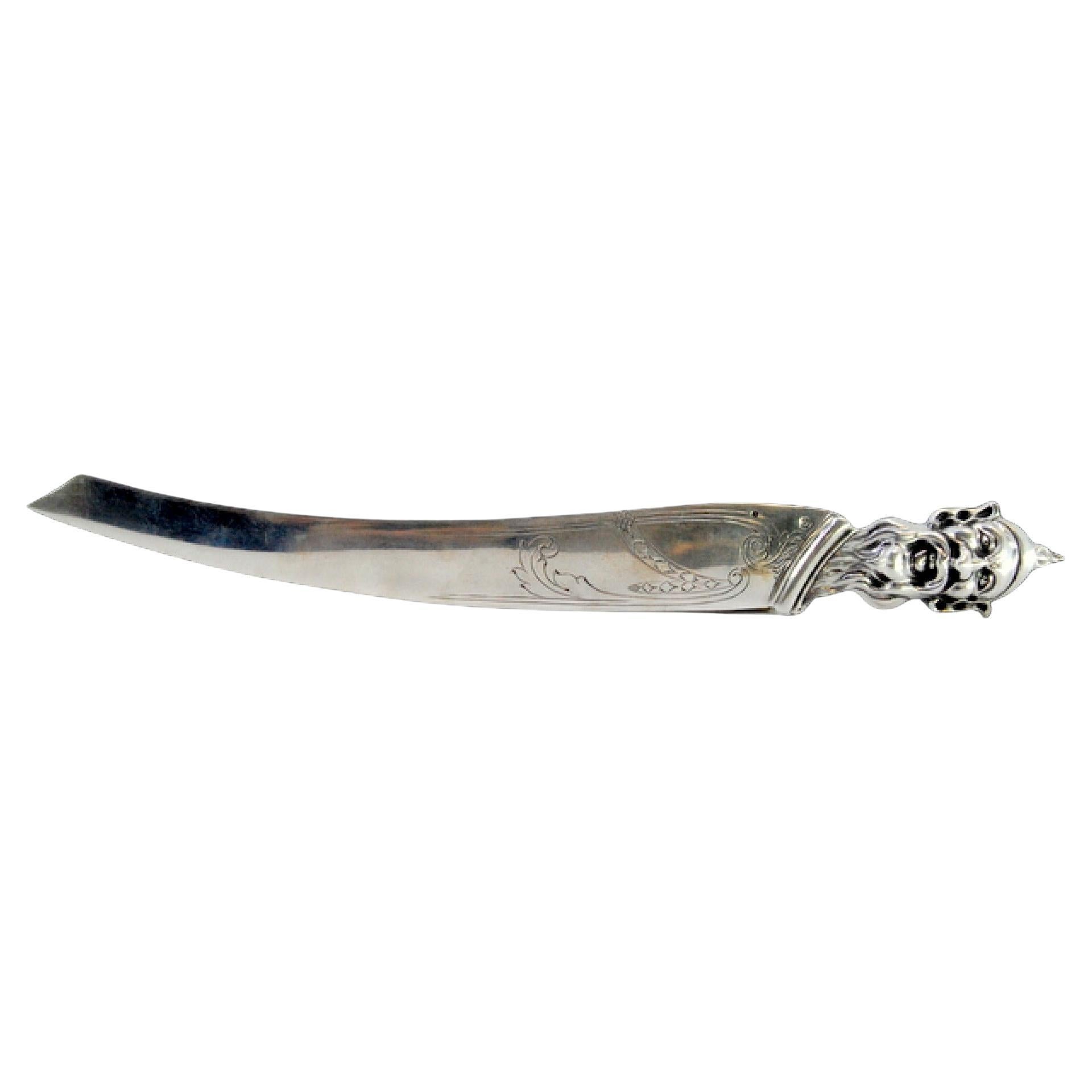 Coupe-papier en argent avec gravure sur la lame et tête de lutin sur la main.