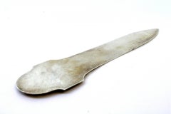 Silver letter opener with wreaths and floral motifs embossed on the handle, engr