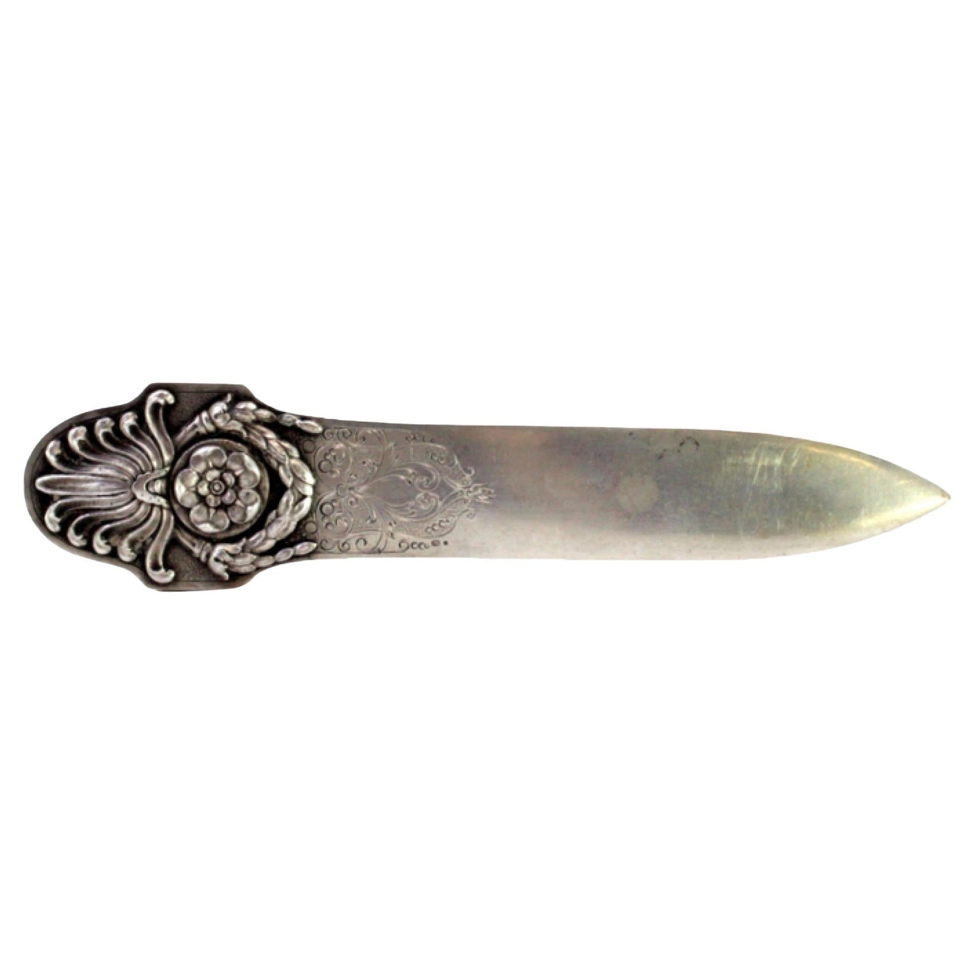 Silberner Brieföffner mit geprägten Kränzen und floralen Motiven auf dem Griff, emailliert