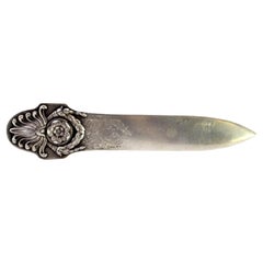 Silberner Brieföffner mit geprägten Kränzen und floralen Motiven auf dem Griff, emailliert
