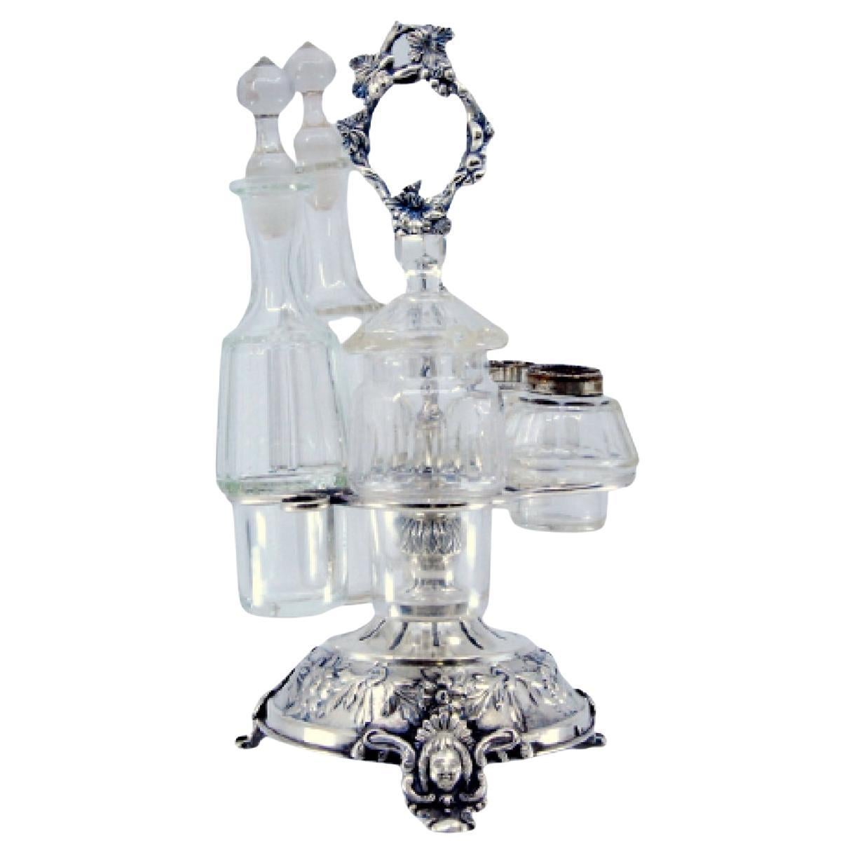 Silver liqueur bottle with floral motifs, mascaron feet, and spice deposits