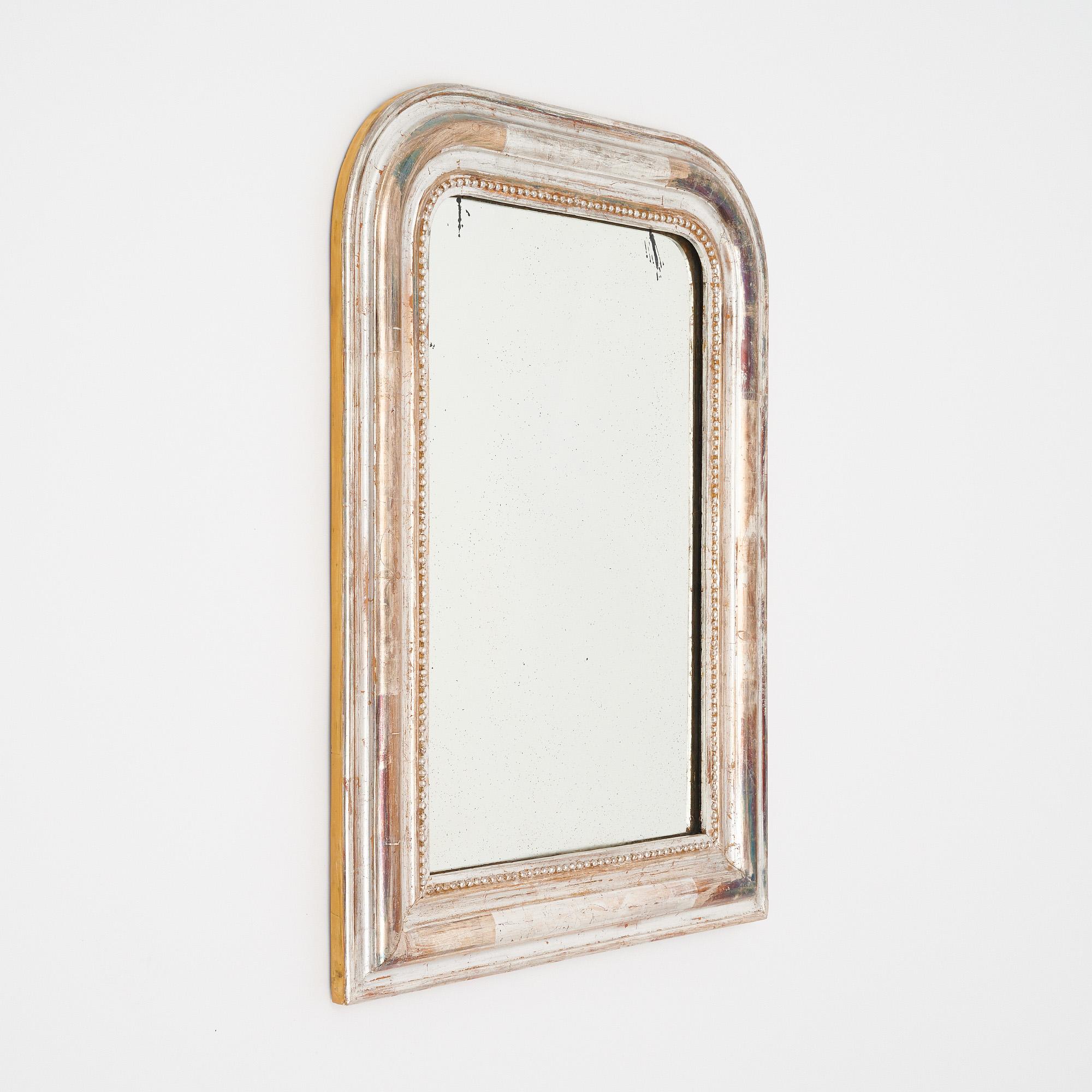 Mirror from the Louis Philippe period in France. This mirror features the original mercury mirror within the classic Louis Philippe molded frame with curved upper corners. The frame is made of solid wood hand carved and stuccoed. This mirror boasts