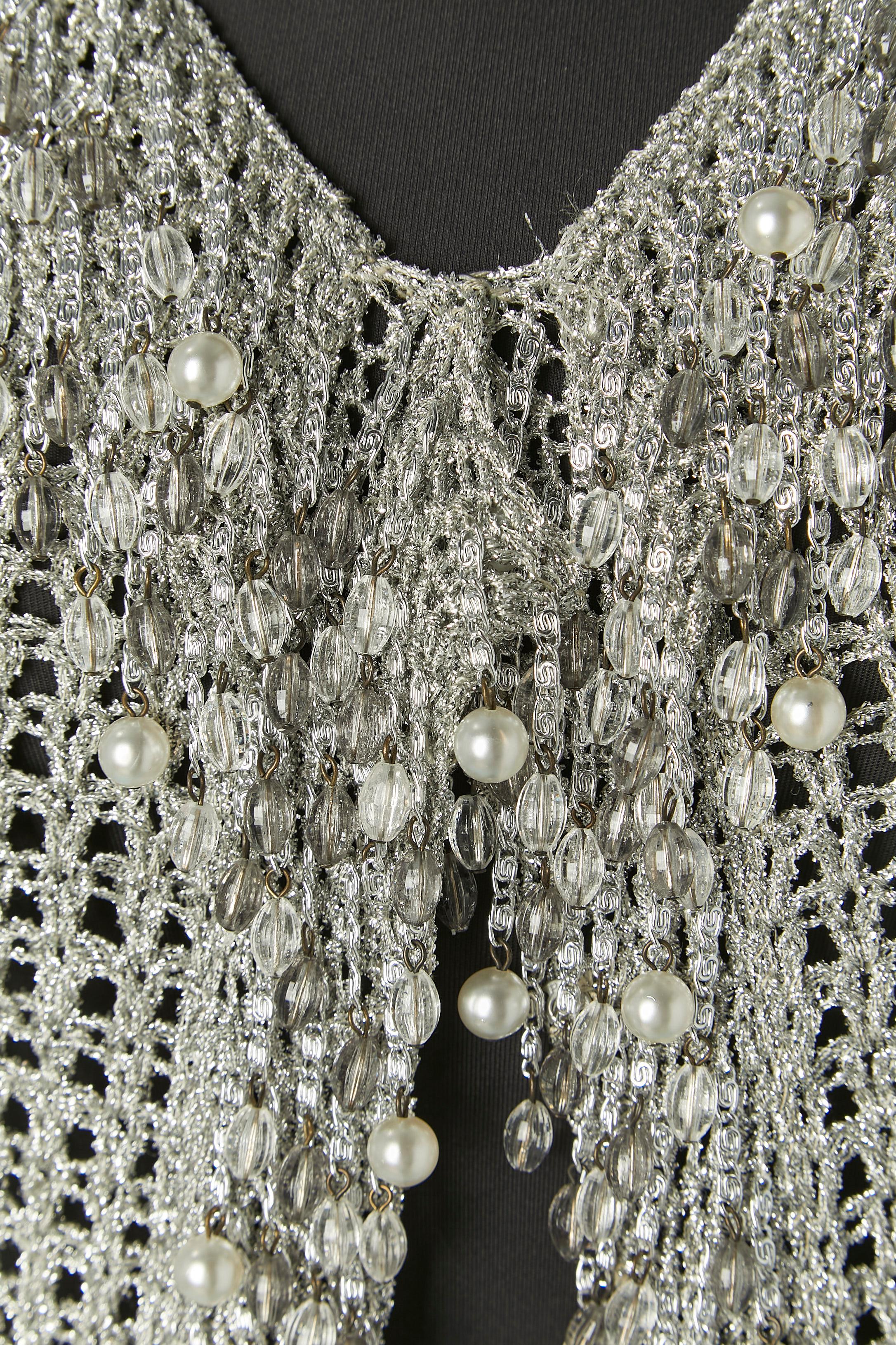 Cardigan in maglia lurex argento con frange di perline. Chiusura a scatto sul centro della parte anteriore 
Taglia S 