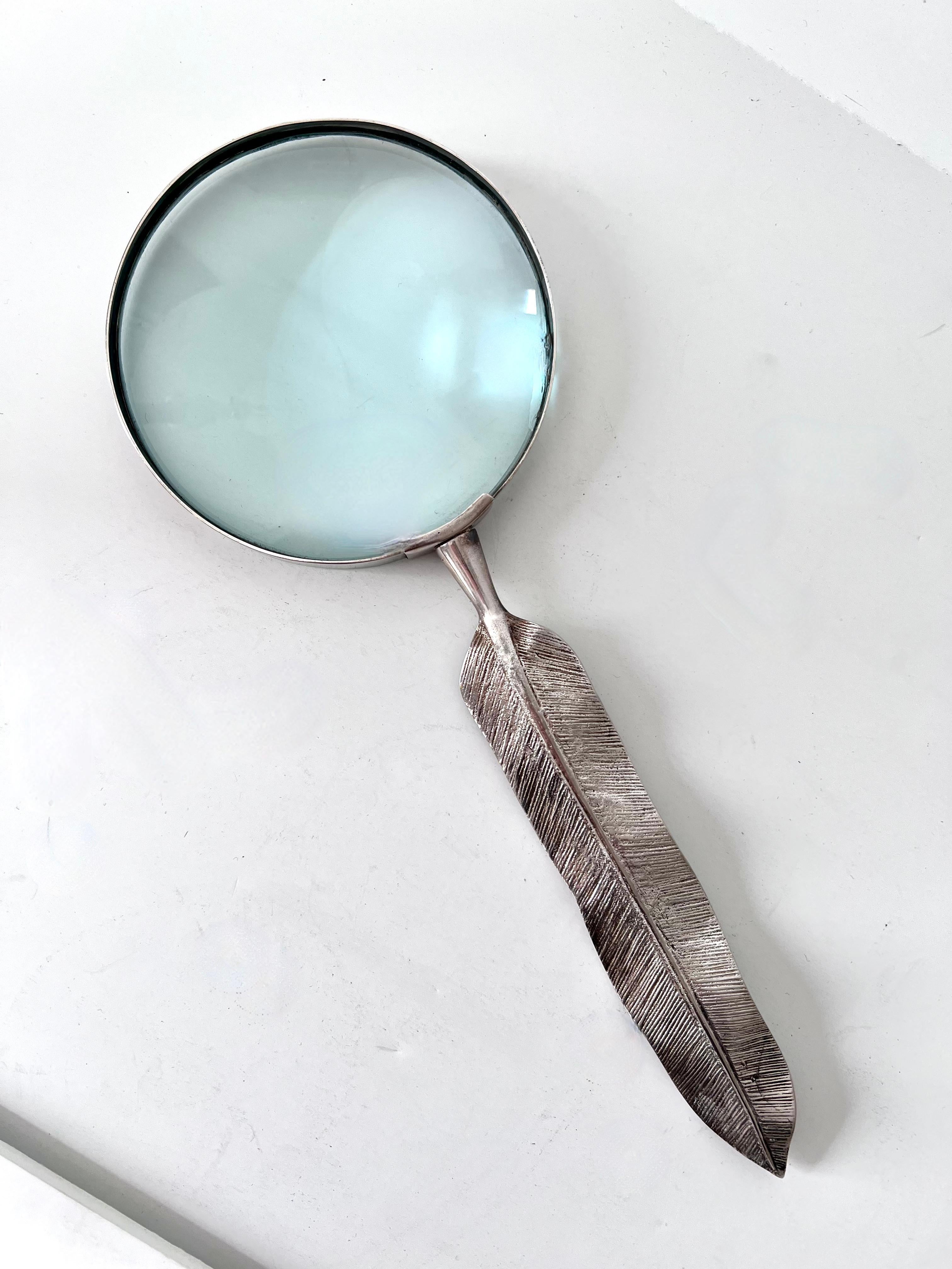 A very nice silver magnifying glass with a feather handle, which could be used for opening letters as well. The magnification is good and works well. A compliment to any desk or work station.