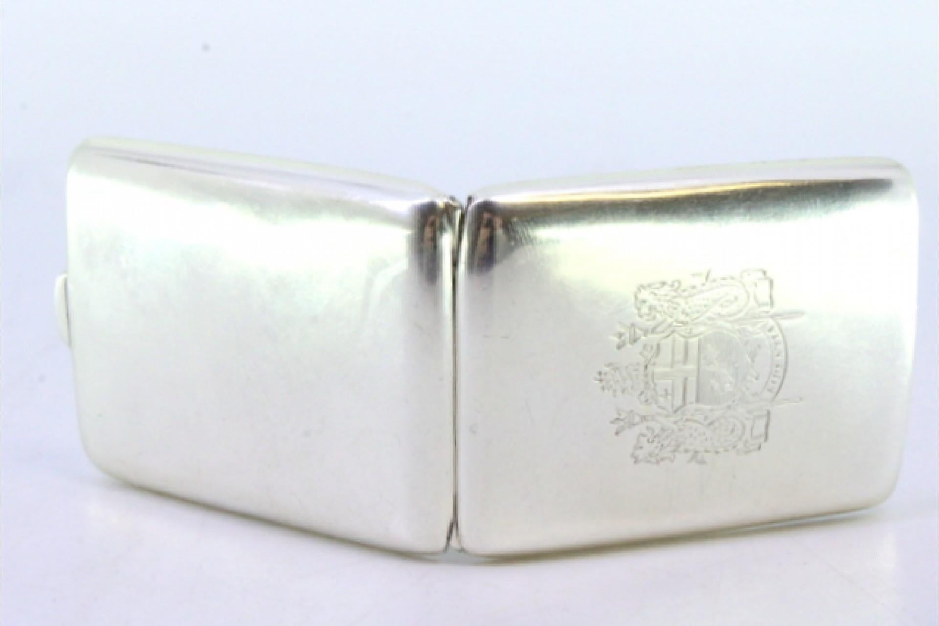 Description: Silver matchbook with coat of arms in the center and hinged lid. Metal: Silver. Origin: English. Brand: Birmingham. Weight: 33.02 grams. Dimensions: 6cmx4.2cm. Content: 925/1000. Assay Mark: Yes, 1937 by Mappin & Webb Ldt. Additional