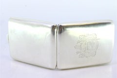 Silver matchbook with coat of arms in the center and hinged lid