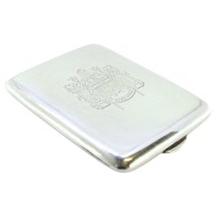 Silver matchbook with coat of arms in the center and hinged lid