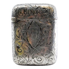 Silver matchstick with relief plant motifs surrounding monogram cartouche