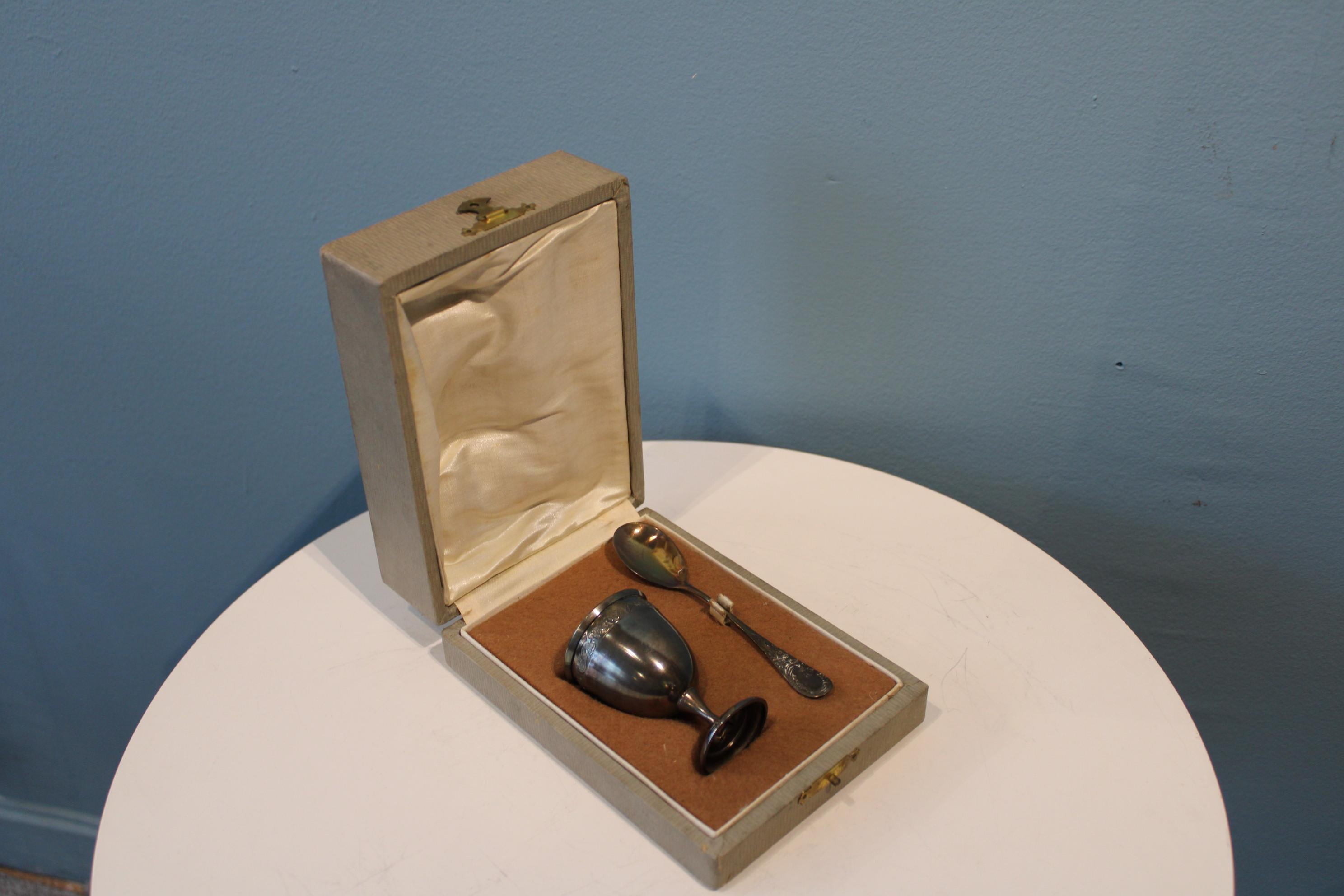 Silver metal, 19th century.

Egg mug dimensions : H 6.5 x diam 4 cm
Spoon dimensions : H 11.5 cm
Box dimensions: 11 x 15 x 6 cm