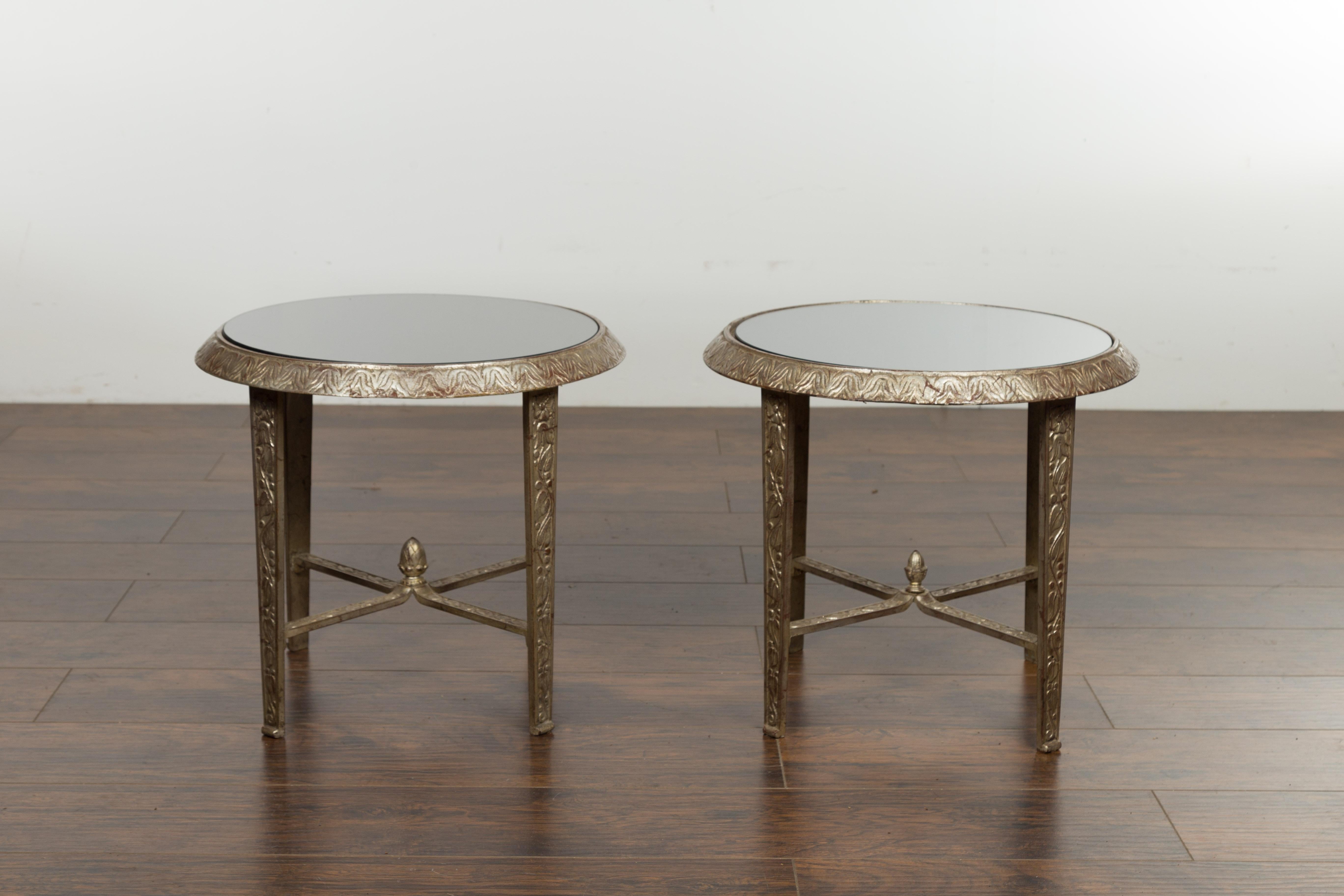 Two silver metal low drinks tables from the early 20th century, with black glass tops and acorn finials, priced and sold $2,400 each. Created during the first quarter of the 20th century, each table features a circular black glass top secured within