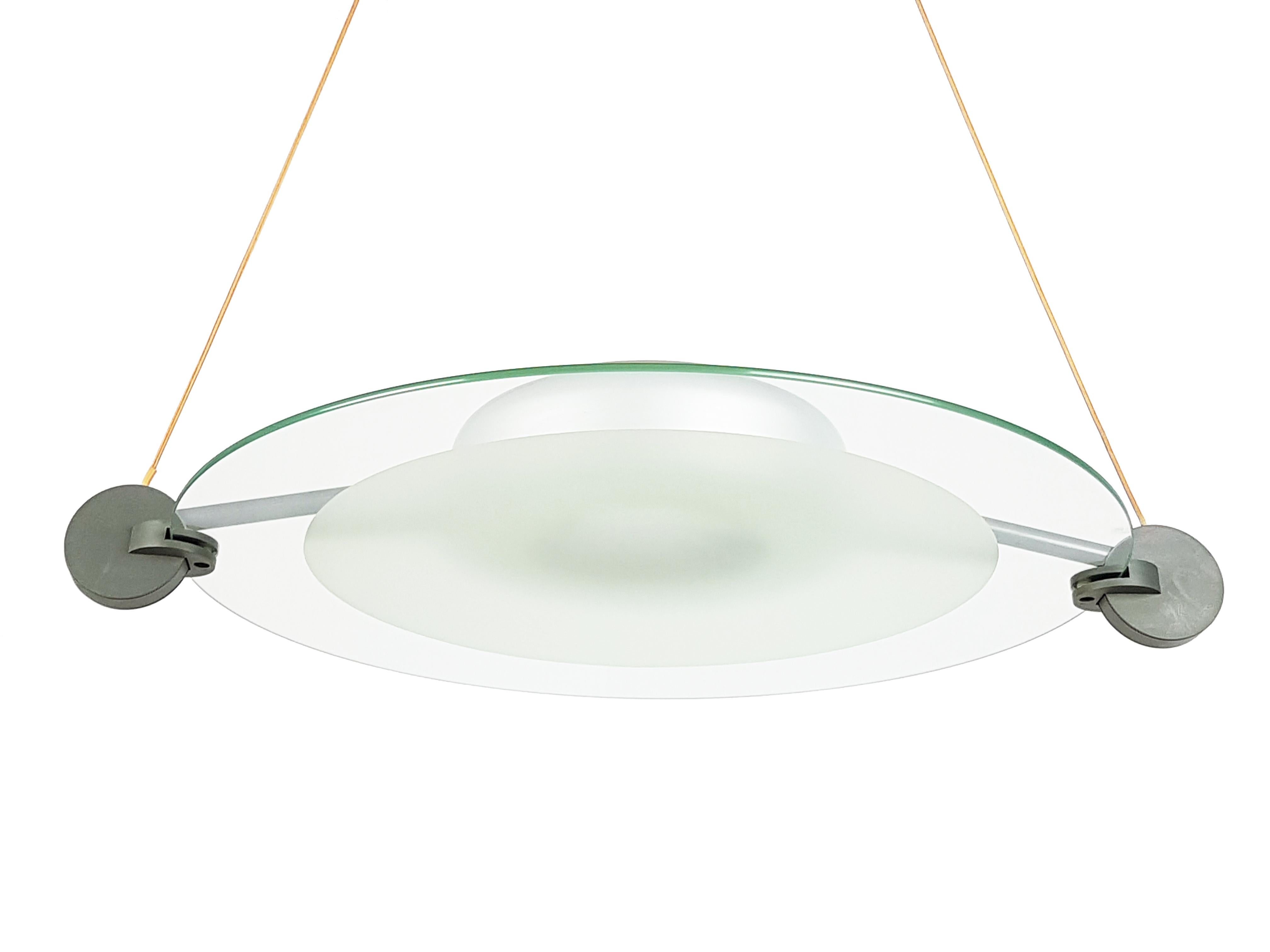 This Postmodern pendant is made from a grey plastic and silver metal structure with a round sandblasted glass shade. It features 2 lamp E27 sockets and remains in very good condition.
A flush mount lamp from the same serie is also available.