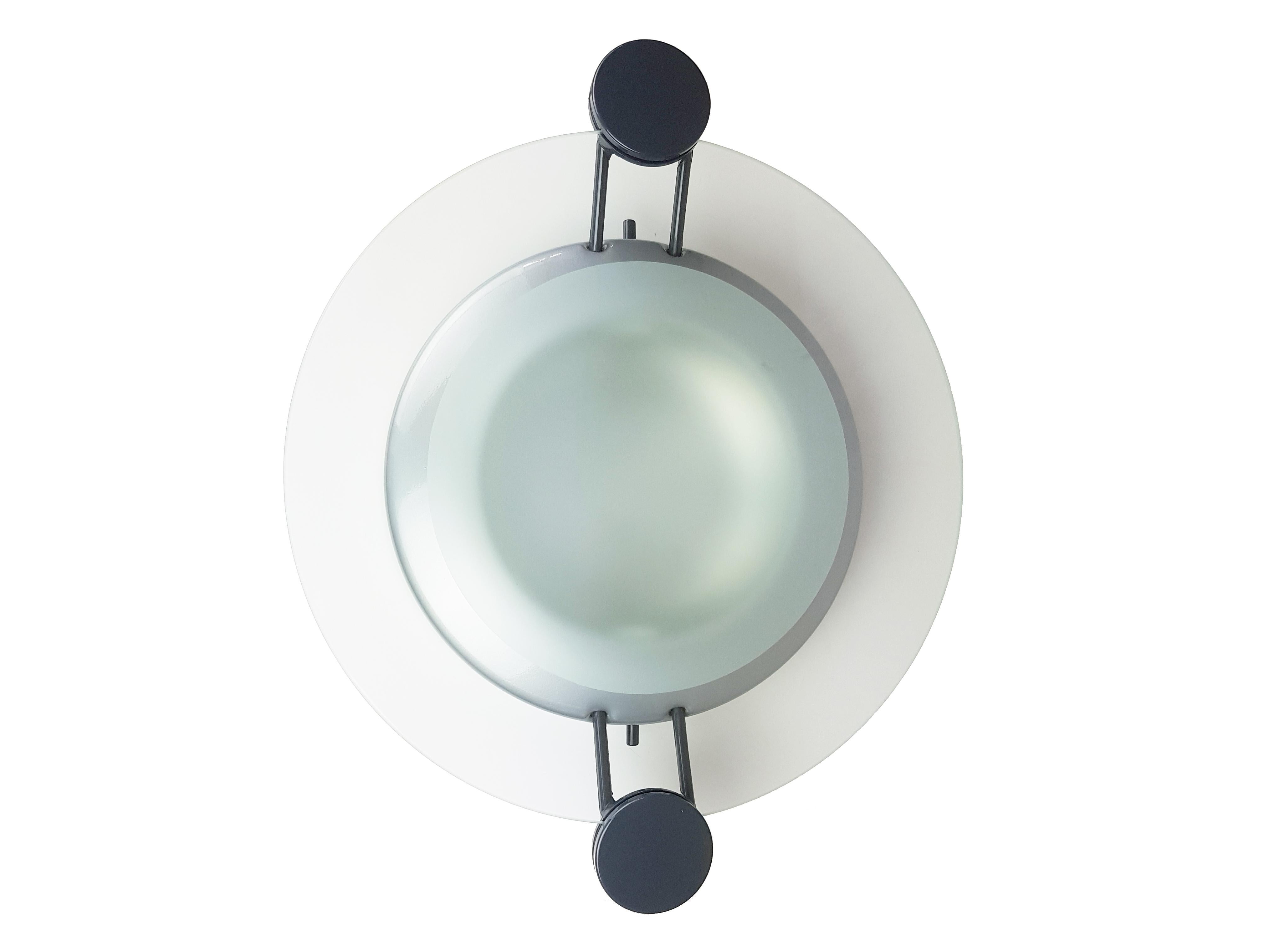 This Postmodern wall or ceiling lamp is made from a grey plastic and silver metal structure with a round sandblasted glass shade. It features 1 lamp E27 socket and remains in very good condition.