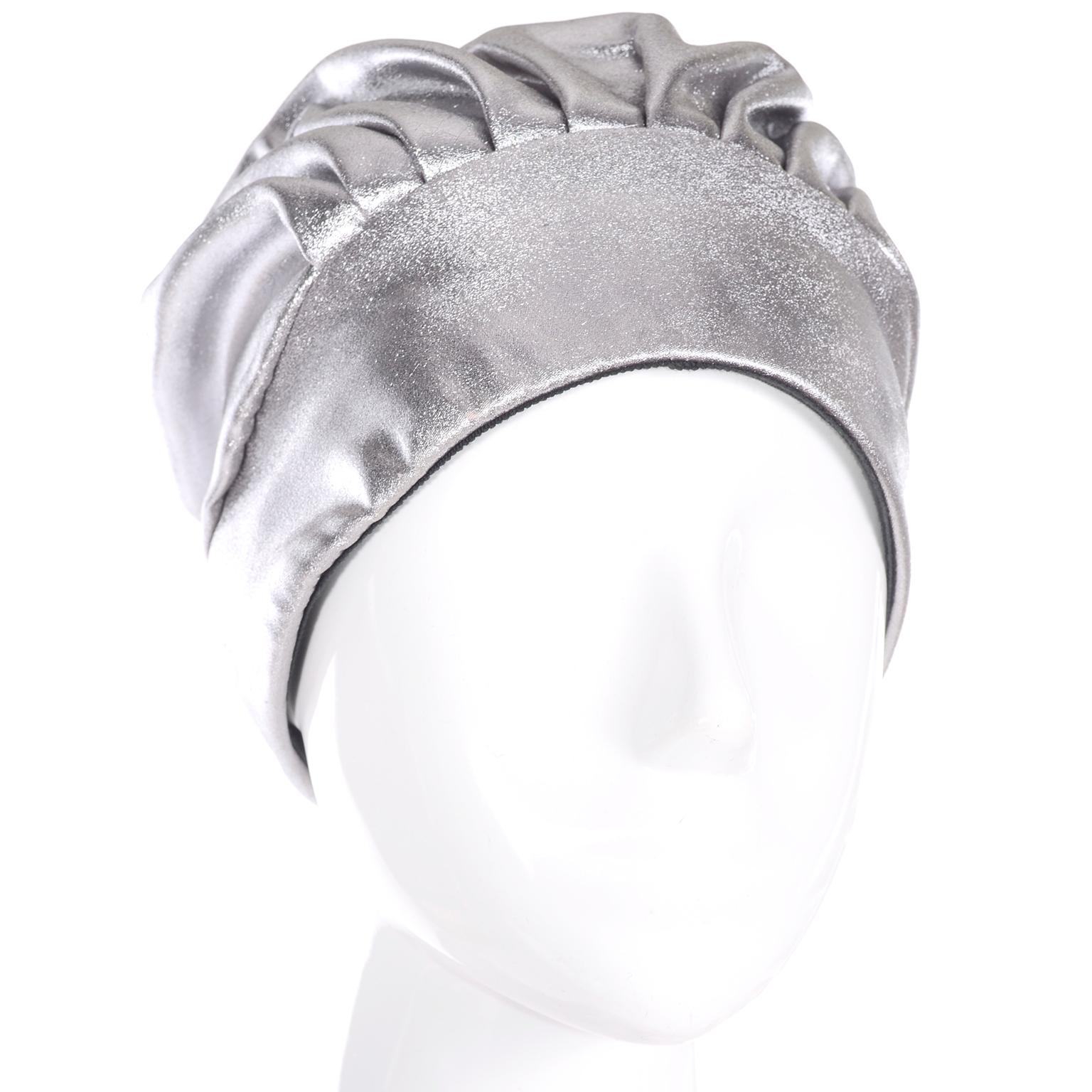 This is a fabulous silver metallic hat with a bonnet or turban style. It is pleated in front and back, with a tie in the very back that hangs down. It is lined in black fabric. The hat has the Nicholas Ungar label from Portland, Oregon. Nicholas