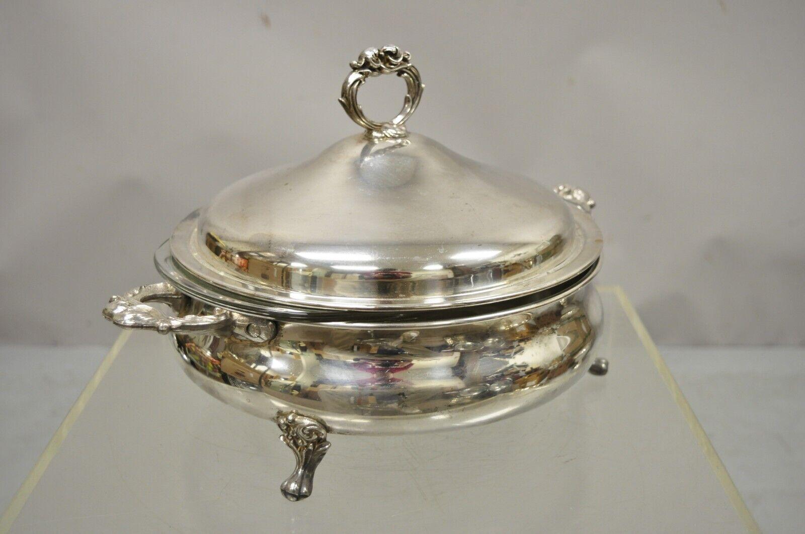 English Silver Mfg Corp silver plate covered platter serving tray dish bowl on feet. Item features pyrex glass liner, ornate domed lid, twin handles, raised on feet. Circa mid 20th century. Measurements: 9