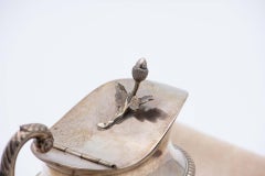 Silver milk jug with embossed lost handle and acorn-shaped knob