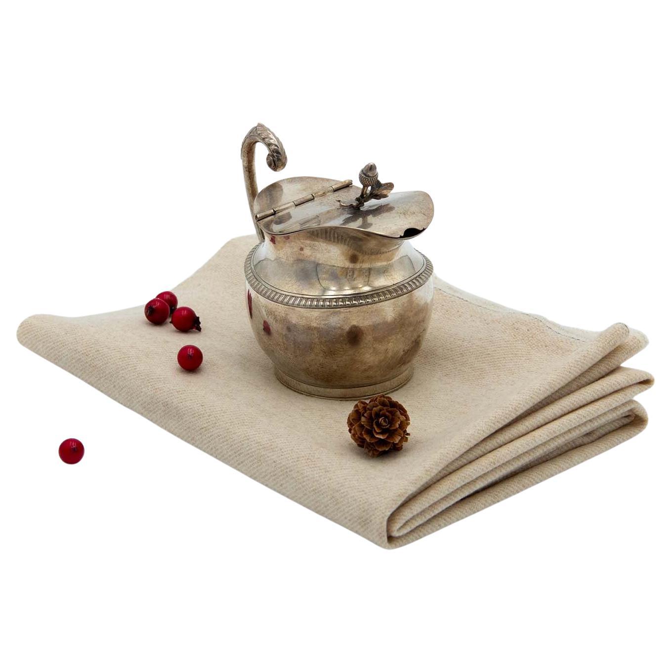 Silver milk jug with embossed lost handle and acorn-shaped knob