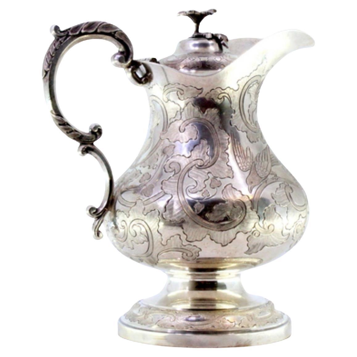Silver milk jug with floral motifs, engraved birds, and flower-shaped knob