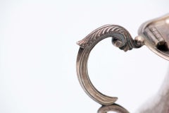 Silver milk jug with four cut-out support legs