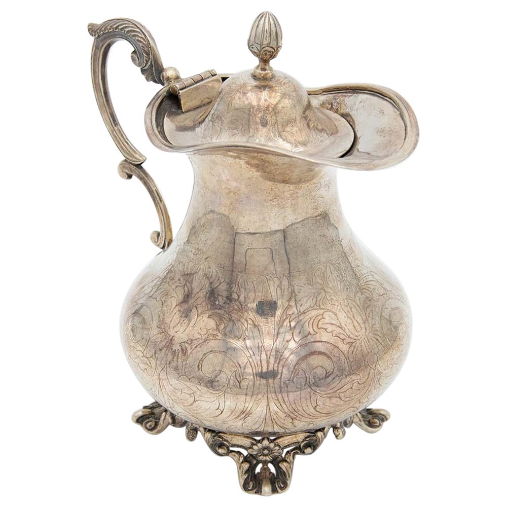 Silver milk jug with four cut-out support legs