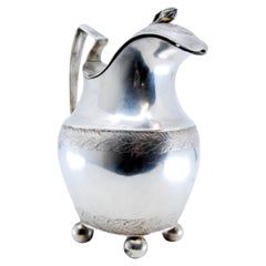Silver milk jug with friezed lid, knob, on four ball feet in D. Maria style