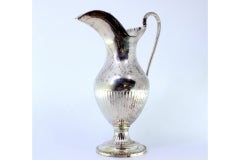 Silver milk jug with knobbed lid and pearly friezes on circular base
