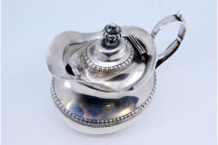 Silver milk jug with pearly trim and knob on the hinged lid