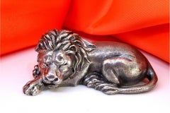 Lion miniature en argent révélé en position couchée