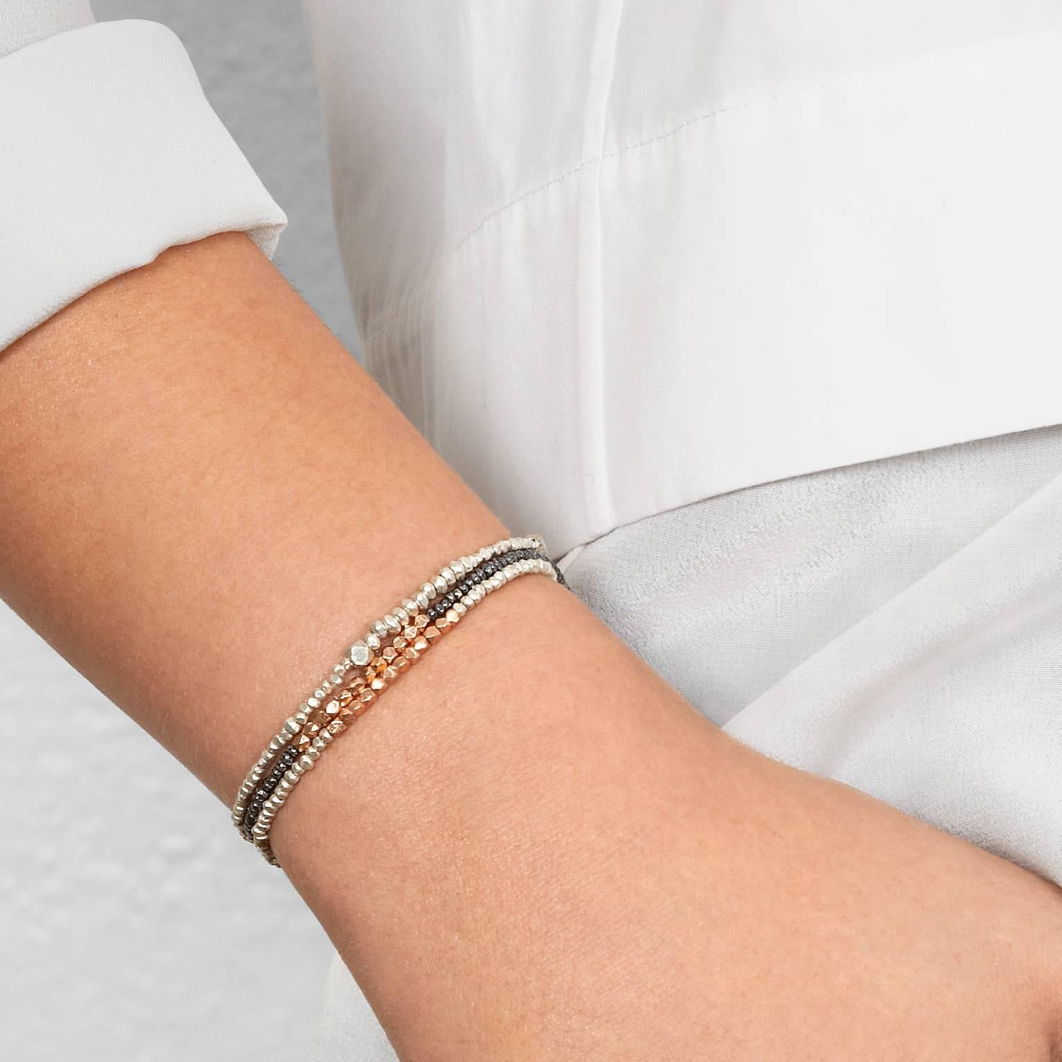 Ce bracelet est orné de perles en argent fin coulé massif, fabriquées à la main et de différentes tailles, enfilées sur un tissu élastique extensible et résistant.  Ce bracelet est unisexe et est disponible en trois tailles : pour femmes, hommes et