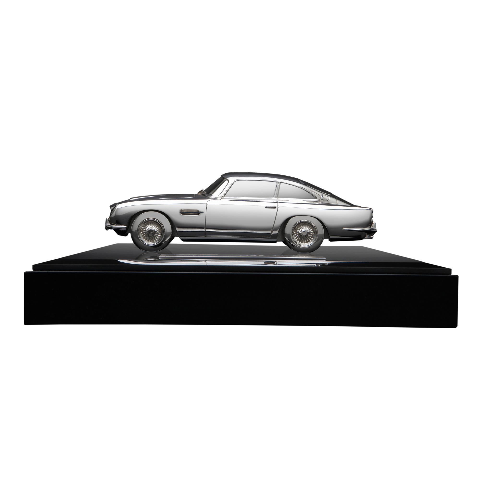 A perfect replica of the iconic DB5, handcrafted in London in hallmarked sterling silver and presented on a wood and glass plinth. This precise 1:30 scale model of Aston Martin's 1963 sports car, is a limited edition of 100 pieces and carries the