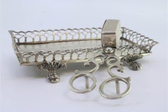 Silver morrões tray & scissors w/ a rack resting on four raised claw-shaped feet