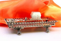 Silver morrões tray & scissors w/ a wire rack & resting on four claw-shaped feet