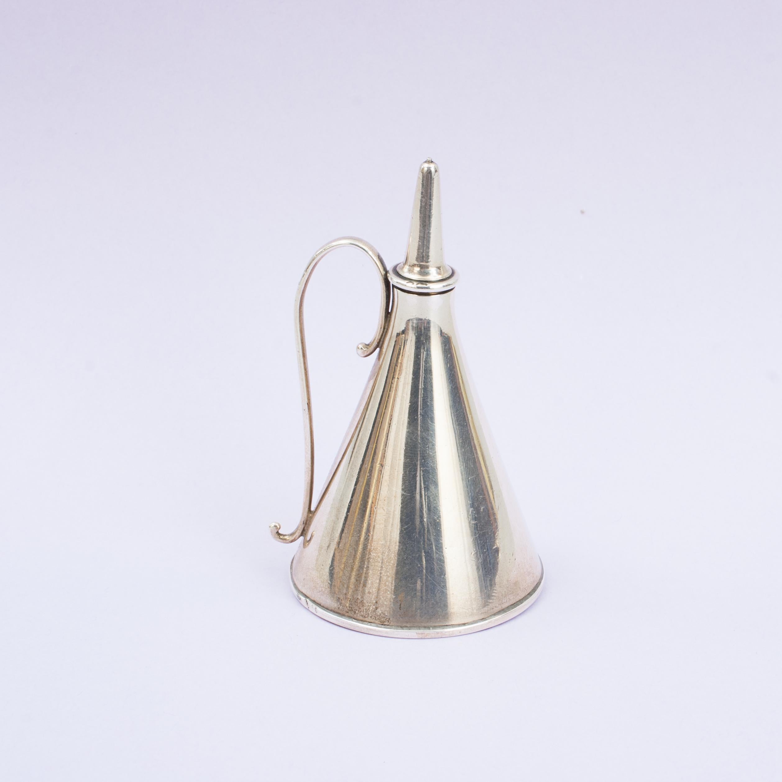 Aceitera cónica de plata Por Jane Brownett & Alexander Jones.
Aceitera victoriana de plata de forma cónica con un tapón de rosca que ayuda a regular el flujo del aceite con una sencilla asa de voluta simple. Con matasellos de Londres de 1880 y la
