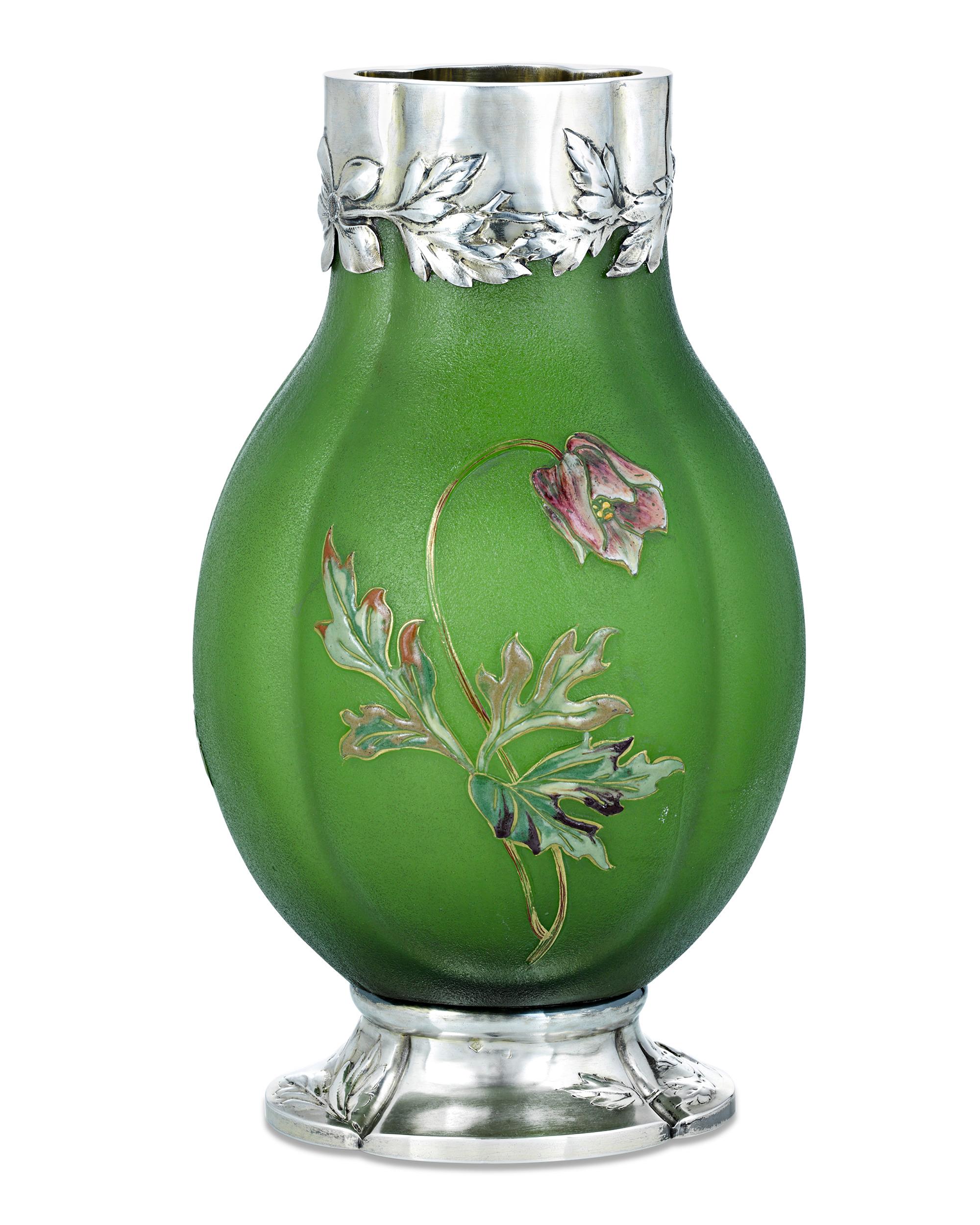 Sterling silver adds a luxurious touch to this rare art glass vase by the incomparable French glass master Émile Gallé. Its bright green body is accentuated by colorful cameo wildflowers in a motif that extends to the silver rim and base. Bearing