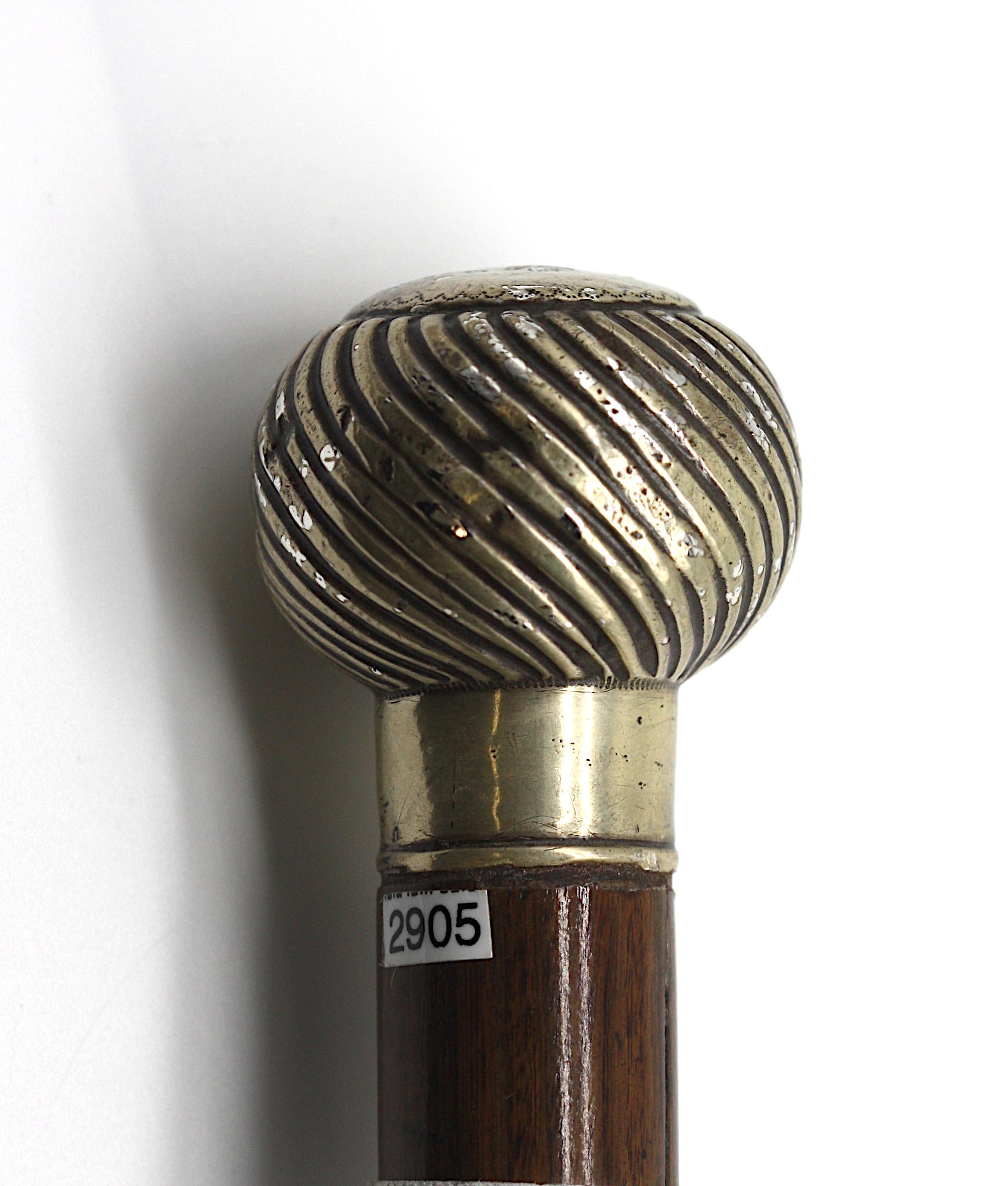 
Silver-Mounted Rosewood Metamorphic Flute Gentlemens Walking Stick. 
Appears unmarked. The spherical pommel chased with spiral reeds, the upper portion a flute with silvered fittings, the rosewood shaft with a metal ferule. 
Length 34.4 in.