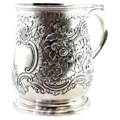 Silver mug with floral reliefs, monogram cartouche and embossed handle