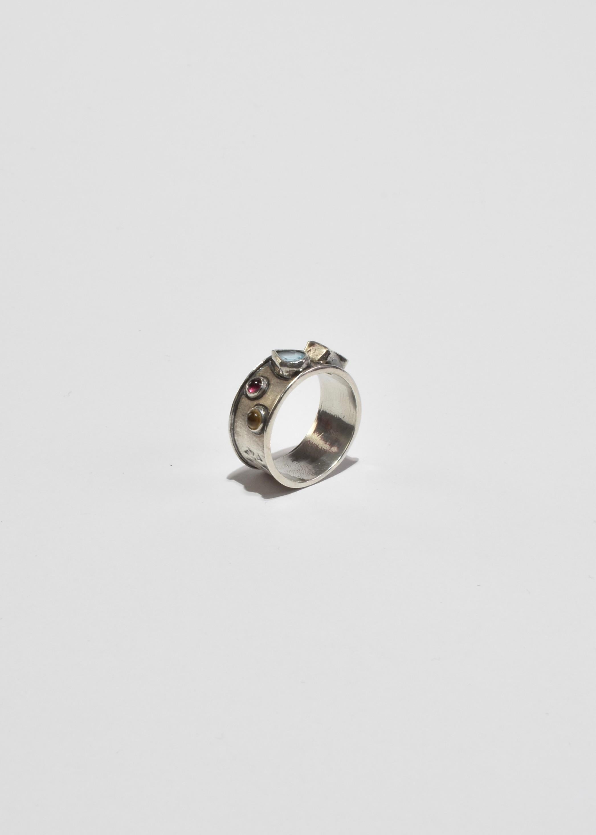 Vintage, handmade sterling ring with colorful stones and stamp detail.

Material: Sterling silver, topaz, amethyst, ruby, citrine.
