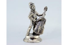 Silver musician playing cello standing on a round, beaded base