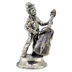 Silver musician playing cello standing on a round, beaded base