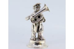Silver musician playing tuba standing on round, beaded base