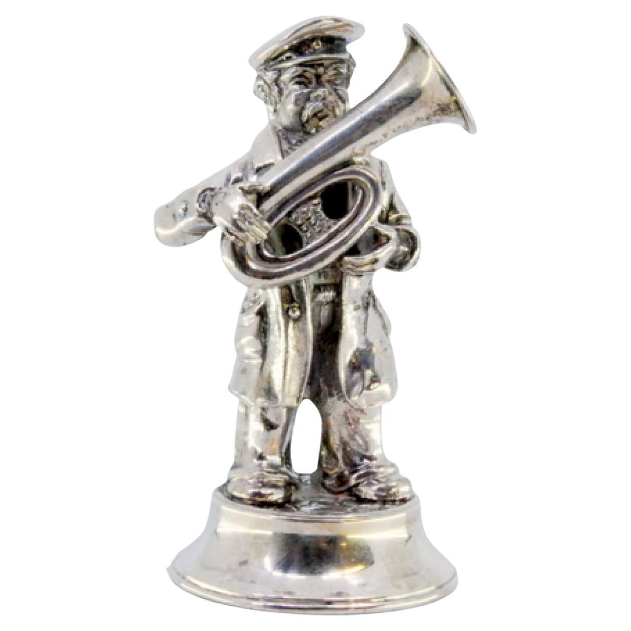 Silver musician playing tuba standing on round, beaded base