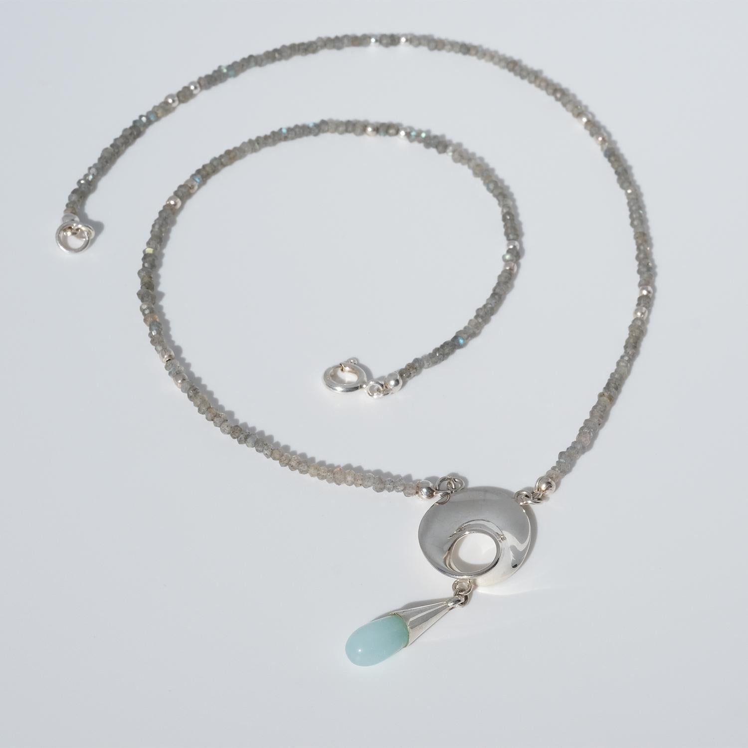 This necklace has a chain made out of faceted shimmering labradorites. The pendant has an organically shaped center section in sterling silver with a movable suspended chalcedony drop. This piece is a rare item.

If you’re a fan of casual outfits
