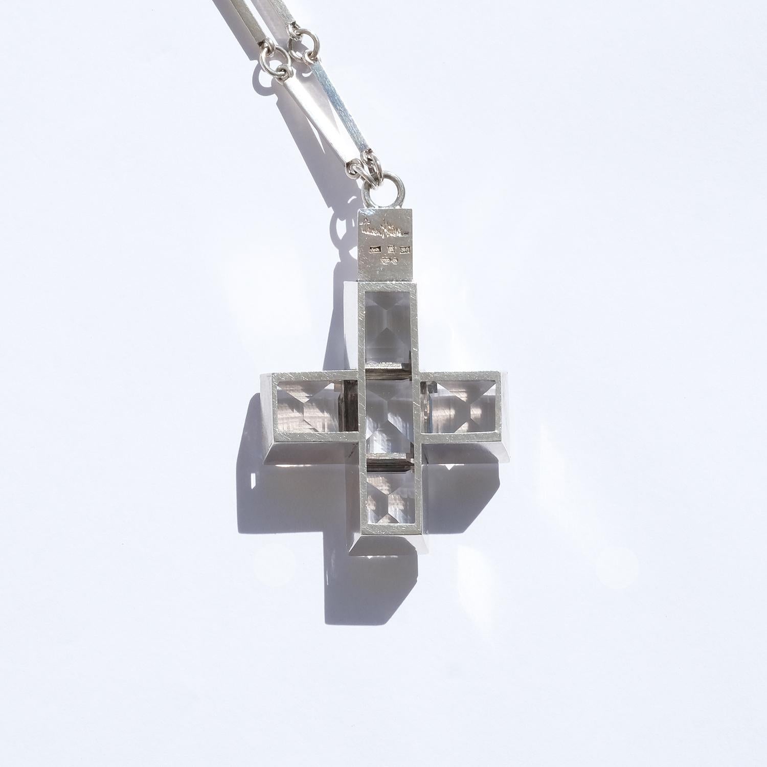 This sterling silver necklace shows upon typical Wiwen Nilsson characteristics; the pendant which is shaped as a Greek cross with square rock crystals, and the ring and bar chain. 

This necklace is perfect for any social event and, if you do not