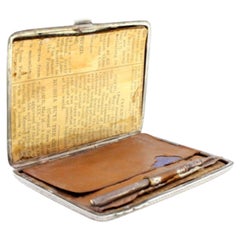 Silver notepad with floral reliefs, pen and leaves