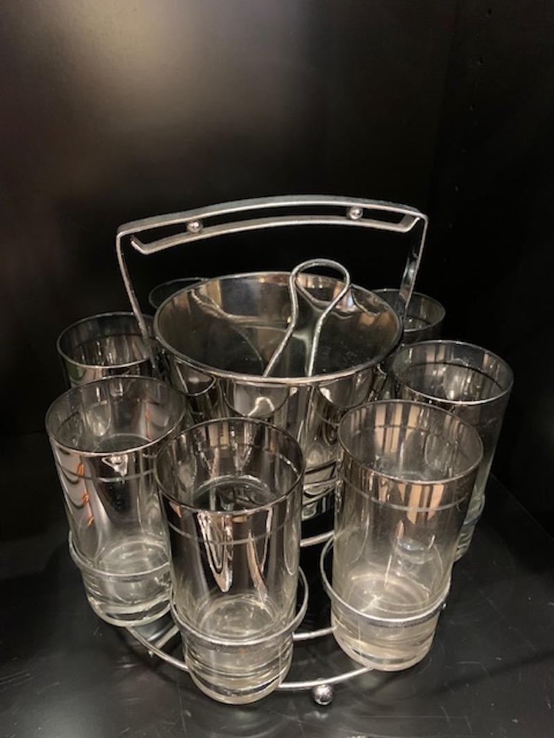 A beautiful set of highball glasses that have a silver ombre that fades from dark to light, and sold with the accompanying caddy and ice bucket, circa 1960.